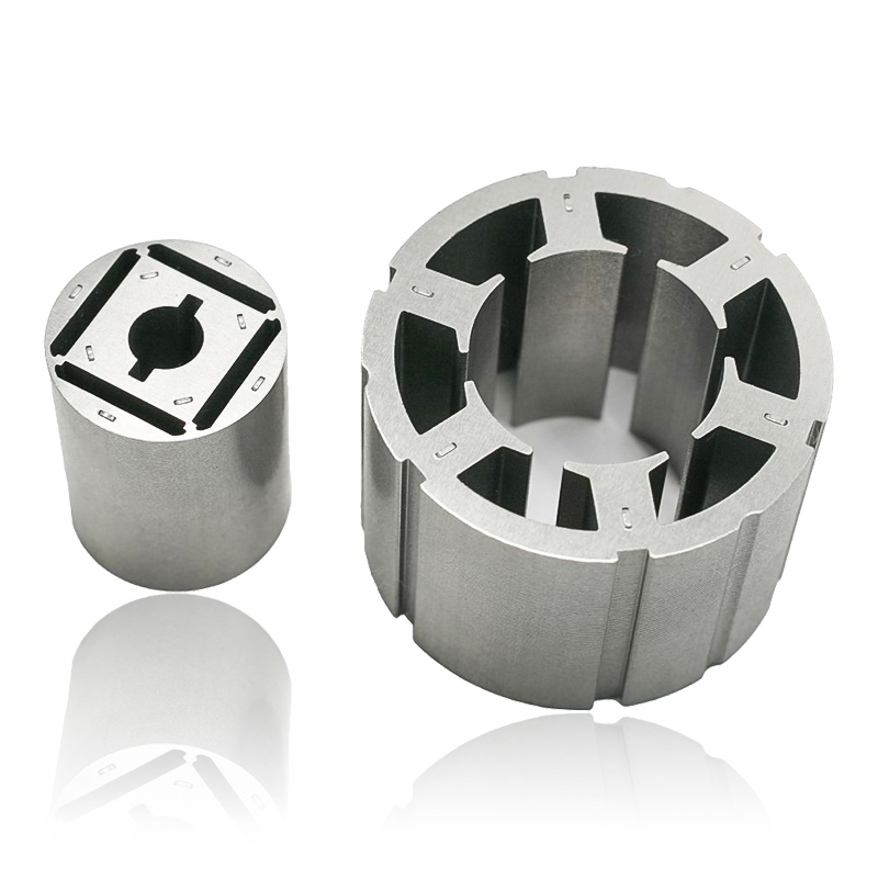 ¿Cómo afecta el espesor de la laminación en los núcleos de rotor y estator de motores automotrices a las pérdidas por corrientes parásitas y al rendimiento térmico?